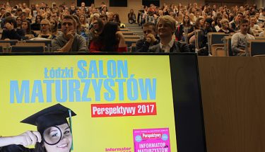 Na pierwszym planie ekran z napisem: łódzki salon maturzystów, w tle aula z uczestnikami spotkania