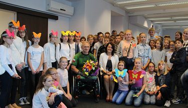 Na zdjęciu Krzysztofe Jarzębski, niepełnosprawny sportowiec w otoczeniu uczniów
