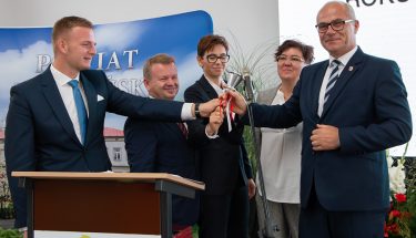 Zdjęcie z inauguracji roku szkolnego 2019/2020 w Wieluniu, kurator i współorganizatorzy uroczystości symbolicznym dzwonkiem ogłaszają nowy rok