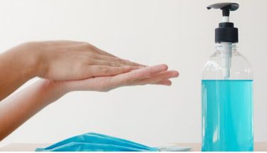 Zdjęcie przedstawiające dłonie i dozownik z mydłem