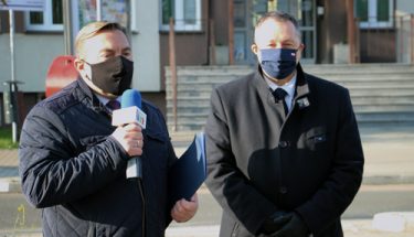 Zdjęcie: kurator Waldemar Flajszer (stojący po prawo) udziela wywiadu dziennikarzowi (stojący po lewo) z sieradzkiej telewizji regionalnej „Ósemka”
