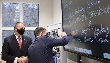 Na zdjęciu dyrektor Powiatowego Centrum Kształcenia w Mroczkowie Gościnnym podpisuje się na tablicy interaktywnej, obok stoi kurator oświaty Waldemar Flajszer