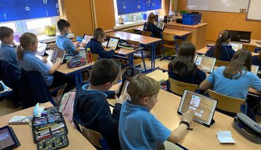 Zdjęcie z lekcji pokazowej w Sportowej Szkole Podstawowej nr 3 w Aleksandrowie Łódzkim: Uczniowie siedza w ławkach patrzą w tablety